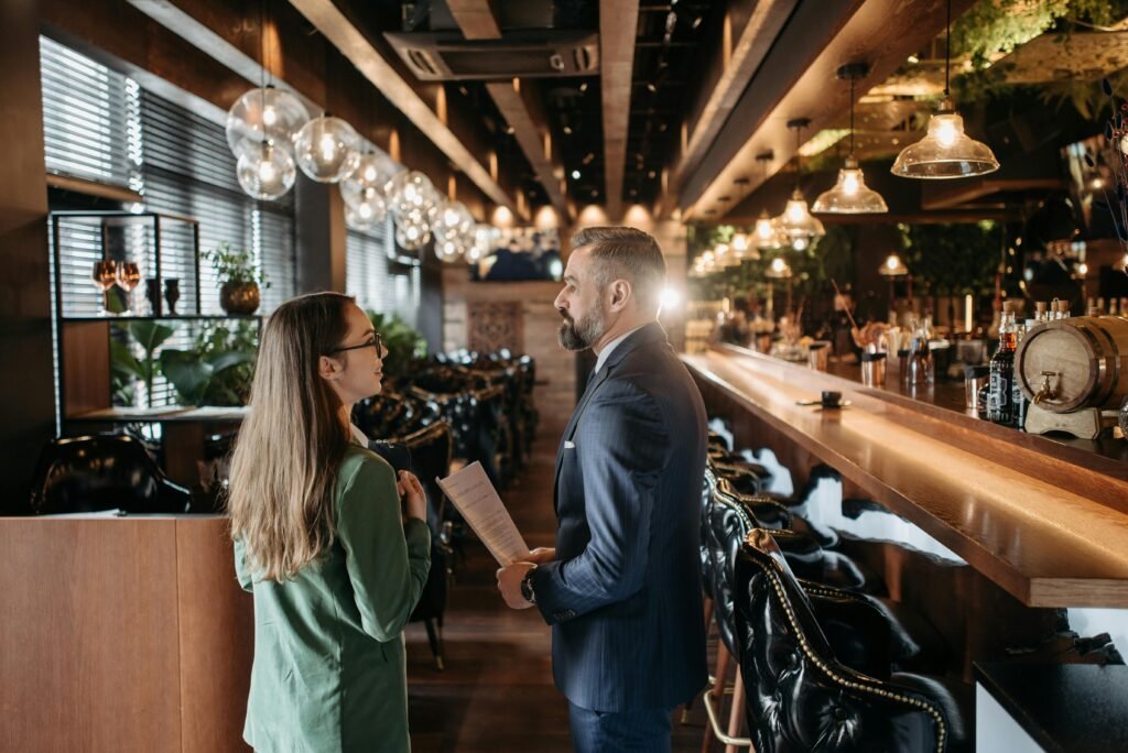 Clientes y camareros en un restaurante moderno, representando el sector hostelero y la atención al cliente.